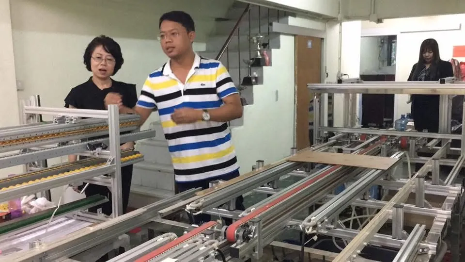 พนักงานชายและหญิงตรวจสอบเครื่องจักรภายในโรงงานอะคริลิค