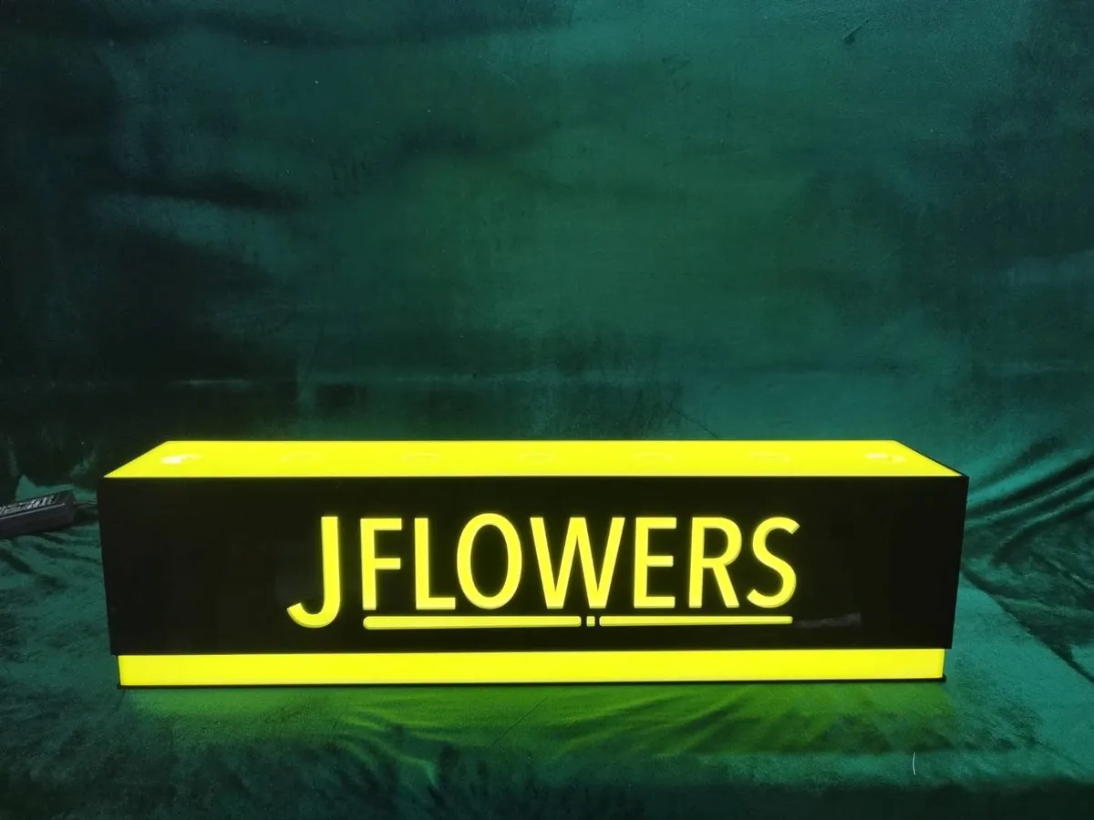 ป้ายกล่องไฟอะคริลิคสีดำฉลุลายตัวอักษร JFLOWERS พร้อมไฟ LED สีเหลืองสว่างสดใส