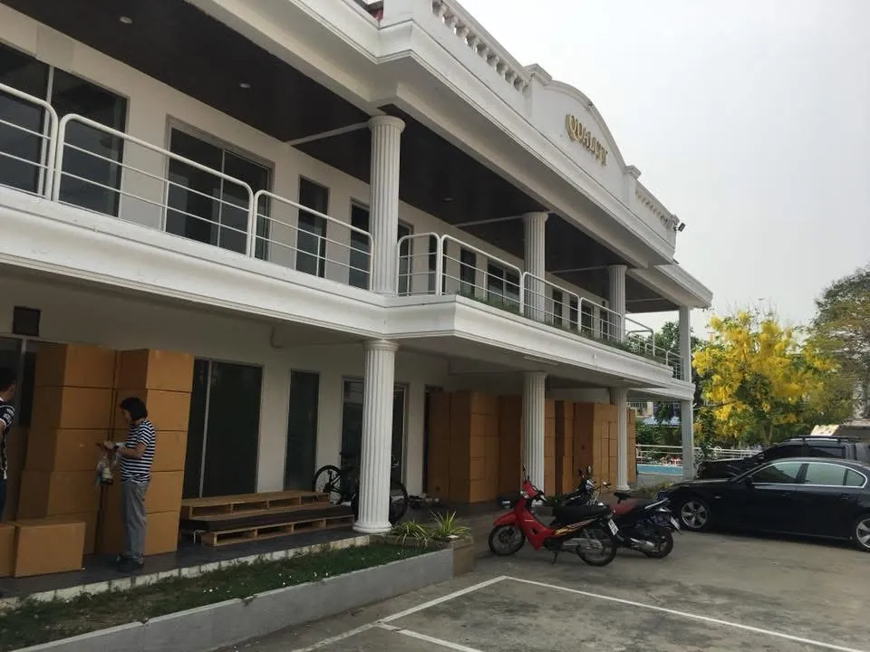 อาคารโรงงานสีขาวสองชั้นพร้อมพนักงานและพื้นที่จัดส่งสินค้า